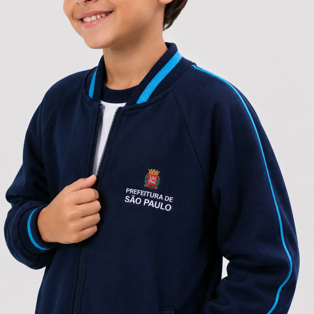 Detalhe da gola, logo, zíper e manga da jaqueta escolar